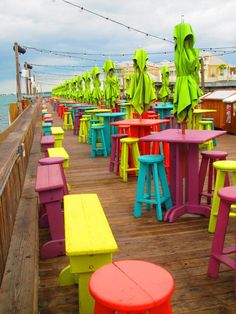 brightly colored tables and chairs on a pier