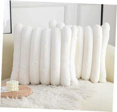 four white pillows stacked on top of each other in front of a mirror and table