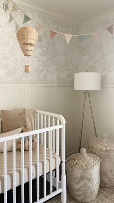 a white crib in a room with two baskets on the floor next to it