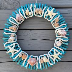 a wreath made out of plastic straws and seashells hanging on a wall