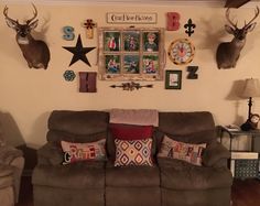 a living room filled with furniture and lots of deer head mounted on the wall above it