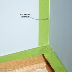 the corner of a room that has been painted white and green with tape on it