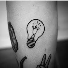 a black and white photo of a light bulb tattoo