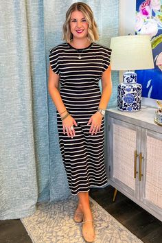 Step into your boldest fall adventure with the Wild Side Midi Dress! With its sleek black base and crisp white stripes, this midi dress channels effortless sophistication and a dash of edge. The fitted silhouette and muscle tee sleeves make it perfect for everything from weekend brunches to evenings out on the town. PRODUCT FIT - TRUE TO SIZE MODEL DETAILS - BRENNA IS WEARING A SIZE SMALL, 5'3" CAROLINE IS WEARING A SIZE LARGE, 5'10" BUST CIRCUMFERENCE -SMALL 38", MEDIUM 40”, LARGE 42” LENGTH -S Casual Striped Midi Dress For Brunch, Striped Midi Dress For Brunch, Casual Black Dress With Striped Hem, Black Casual Dress With Striped Hem, Striped V-neck Midi Dress For Work, Black Dress With Vertical Stripes And Short Sleeves, Black Short Sleeve Dresses With Vertical Stripes, Black Short Sleeve Dress With Vertical Stripes, Chic Striped Knee-length Midi Dress