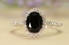 a black and white diamond ring sitting on top of a table