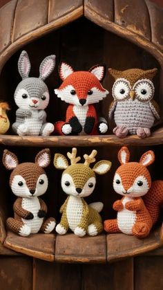 several crocheted animals are sitting in a wooden shelf with one animal on it's side