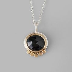 I love the striking black of this spinel with its sparkling facets in contrast with the soft brushed gold and silver the border it. Handmade from sterling silver with 14k yellow gold discs and bezel around a rose cut black spinel. Hangs on an 18" chain. Pendant measures 3/4" by a little over 1/2" Arrives to you in a special gift box. Black Gemstone Necklace, Aura Necklace, Black Onyx Pendant, Gold Disc, Black Spinel, Opal Pendants, Chain Pendant, A Rose, Stone Necklace