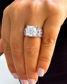 a woman's hand with a diamond ring on her finger and an engagement band