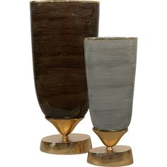 two vases sitting side by side on top of each other in gold and grey