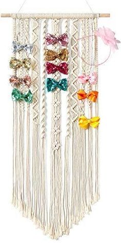 a multicolored bow tie hanging from a wooden hanger on a white wall