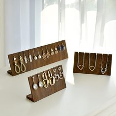 three wooden jewelry racks with earrings on them