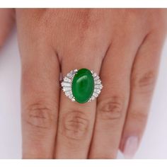 5.32 carats of true green untreated jadeite jade are displayed as the focal point of this beautiful piece. This ballerina style ring features a platinum band with delicate filigree, the lush green oval cut gemstone rests proudly at its head. 16 brilliantly shining baguette cut diamonds hug the center stone, 8 on each side, totaling 1.34 carats.   The center stone is HK Stone and Lab Certified. It's a Fei Cui Grade A untreated Jadeite Jade.   Details: Item Type: Ballerina Ring Metal: Platinum 900 Size: 6 1/4 Weight: 8.80 Grams Setting: Cathedral, Filigree  Center Stone Details: Stone Type: Untreated Jadeite Jade (Fei Cui) Grade: A  Carat: 5.32 Cut: Oval Cabochon Color: Intense Green Treatment: None Measurements: 16.09 x 10.30 x 3.60 MM   Hong Kong Jade & Stone Laboratory Certified  Side Sto Jade Rings For Women, Ballerina Ring, Jade Rings, Ballerina Style, Green Oval, Baguette Cut Diamond, Ring Metal, Jade Stone, Baguette Cut