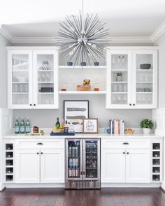 a kitchen with white cabinets and stainless steel appliance in the center, along with wooden floors