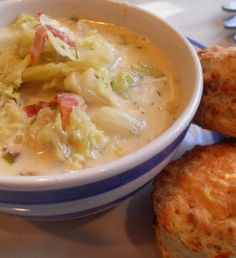 a bowl of soup and two pastries on a table