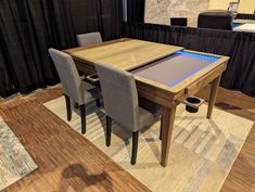 a dining room table with an illuminated tabletop in the center and four chairs around it