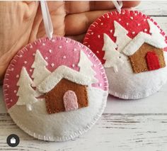 two handmade christmas ornaments are shown on a white wooden surface, one is pink and the other is red