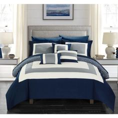 a bed with blue and gray comforters in a room