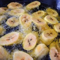 sliced bananas frying in oil in a pan on the stove top, ready to be cooked