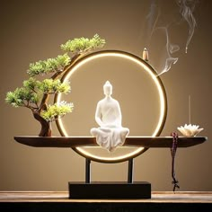 a buddha statue sitting on top of a wooden table next to a bonsai tree