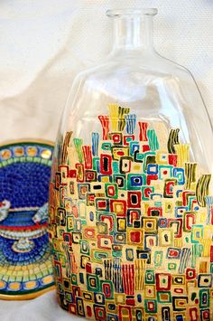 a glass vase sitting on top of a table next to a decorative plate and bowl