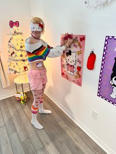 a woman in hello kitty costume is hanging pictures on the wall