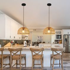 a kitchen with white cabinets and marble counter tops