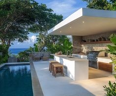 an outdoor kitchen next to a swimming pool