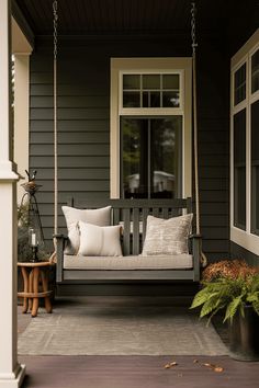 a porch swing with pillows on it