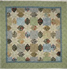 a green and blue quilt with many different designs on the front, back and sides