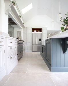 a large kitchen with white cabinets and blue counter tops, along with an island in the middle