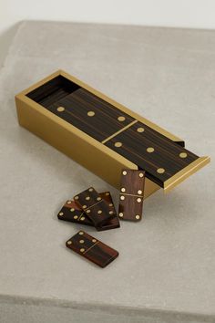 three wooden dominos sitting in a box on top of a cement surface next to each other