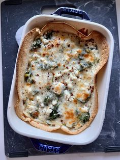 a casserole dish with broccoli and cheese in it on a tray