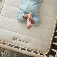 a young child laying on top of a mattress