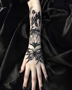 a woman's arm with tattoos on it and a bow around the wrist,