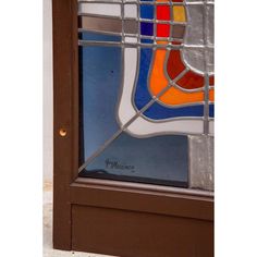 a close up of a stained glass window on a door with metal bars and screws