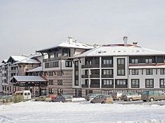 cars are parked in front of a large building on a snowy day with snow covering the ground