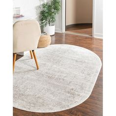 a white rug with a chair and potted plant on the floor next to it