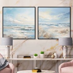 two paintings hanging on the wall in a living room with pink chairs and a coffee table