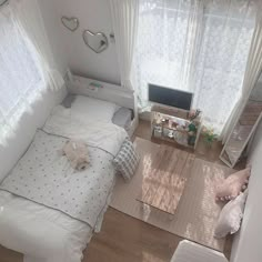 an aerial view of a small bedroom with a bed, desk and television in the corner