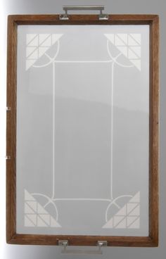 a wooden frame with white and brown designs on the glass inlayed to it