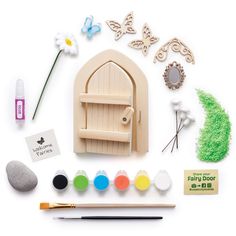 an assortment of crafting supplies including paint, paper and wooden toys on a white surface