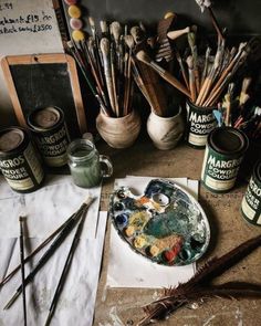 an image of some art supplies on a table with paintbrushes and other items