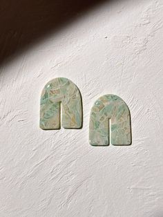 two green and white ceramic letters sitting on top of a wall