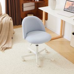 a blue office chair sitting on top of a white floor next to a computer desk