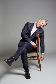 a man sitting in a chair wearing a suit and tie