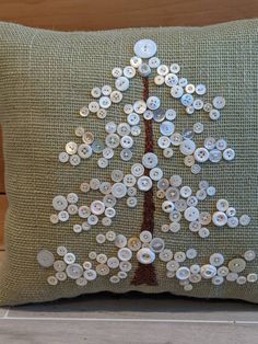 a green pillow with buttons on it and a tree made out of the same fabric