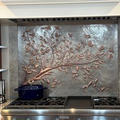 a stove top oven sitting inside of a kitchen next to a wall with leaves on it