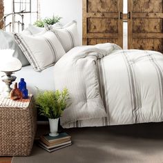 a bed with white sheets and pillows in a bedroom next to a wooden headboard