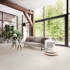 a modern living room with large windows and white carpeted flooring that looks like stone