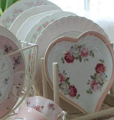 there are many plates and cups on the table together, including one with a heart